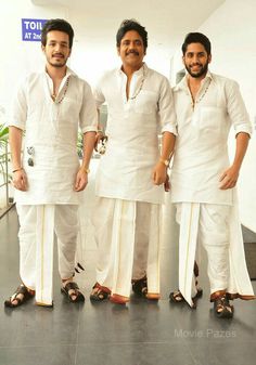 three men standing next to each other in white outfits