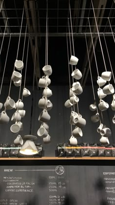 many white cups hanging from strings in a room