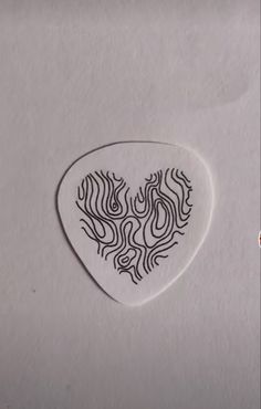 a white guitar pick with black designs on it