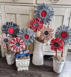 some red white and blue flowers are in vases