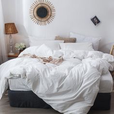 an unmade bed with white sheets and pillows