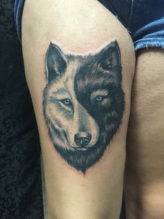 a close up of a person's thigh with a wolf tattoo on the leg