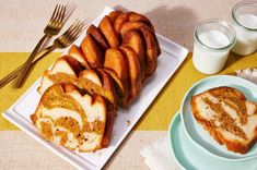 slices of cinnamon bundt cake on plates next to glasses of milk and utensils