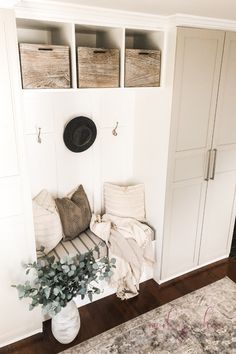 a room with white walls and wooden flooring is decorated in neutral tones, such as the entryway