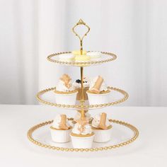 a three tiered cake stand with cupcakes on it