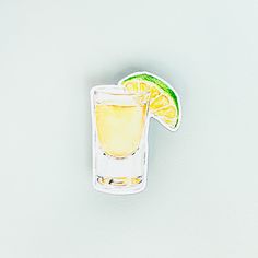 a glass filled with lemon and lime sitting on top of a white table next to an orange slice