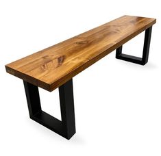 a wooden bench sitting on top of a black metal frame stand next to a white wall