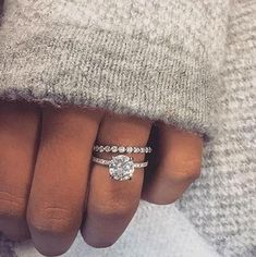 a woman's hand with three different rings on her fingers and the other one is wearing