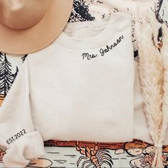 a hat, t - shirt and feather on a table