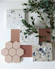 four tiles with different shapes and colors on them next to a green plant in the middle