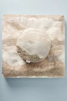 a round object is sitting on top of a piece of paper that has been torn off