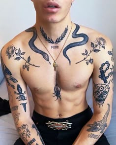 a man with many tattoos on his chest and arms is posing for a selfie