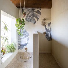 a bathroom with plants hanging from the ceiling and tiled flooring, along with a bathtub