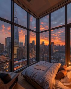 a bedroom with large windows and a view of the city at sunset or dawn,