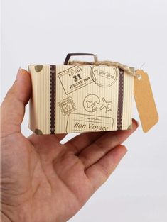 a hand is holding a small box with some stickers on it