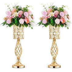 two gold vases with pink and white flowers on top of eachother,