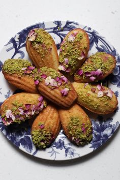 a plate filled with pastries covered in green and pink toppings on top of it