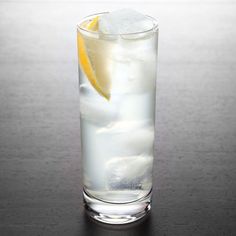 a tall glass filled with ice and lemon