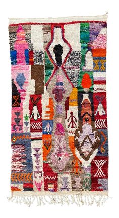 a multicolored patchwork rug with fringes on the bottom and an arrow in the middle