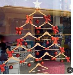 there is a christmas tree in the shop window with red and white bows on it