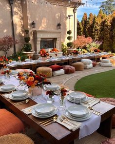 a table set up with plates and place settings in front of an outdoor dining area