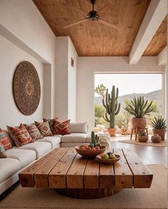 a living room filled with furniture and a wooden table in front of a large window