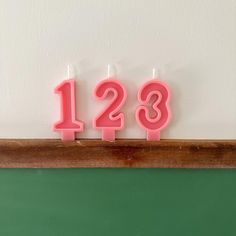 two candles that are shaped like numbers on a shelf