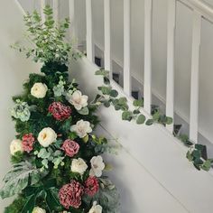 flowers and greenery are growing up the side of a stair case in a home