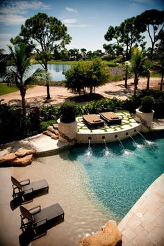 an outdoor swimming pool with lounge chairs around it