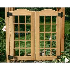 two wooden doors are open in the garden