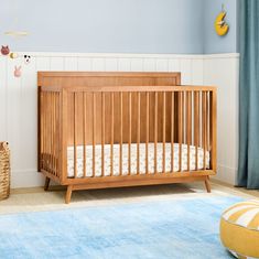 a baby crib in the corner of a room with blue walls and rugs