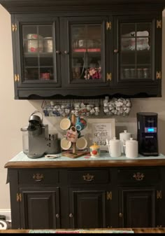 a kitchen with black cabinets and coffee maker