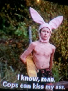 a young man in bunny ears holding a surfboard