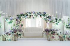 a white couch sitting under a flower covered arch