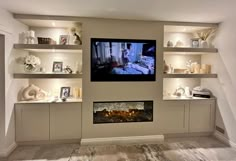 a flat screen tv mounted to the side of a wall next to a fire place