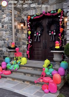 halloween decorations on the front steps of a house with pumpkins, balloons and skeletons