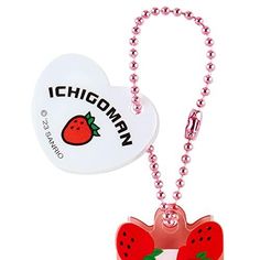 a heart shaped keychain with a strawberry on it and a tag attached to it