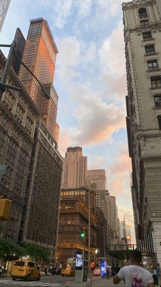 a man standing on the side of a road in front of tall buildings and traffic lights