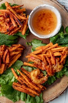 some food is on a plate with lettuce and dipping sauce next to it