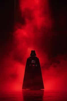 darth vader standing in the dark with red fog