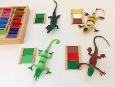 several toy animals are arranged on a white surface with colored pencils and erasers