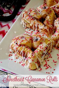 a white plate topped with donuts covered in icing and sprinkles