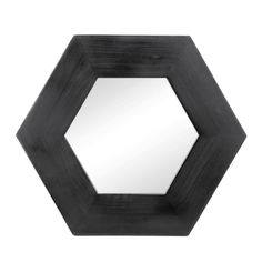 a black hexagonal mirror sitting on top of a white wall