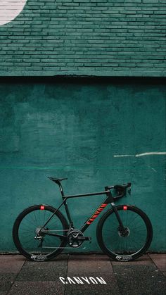 a bike parked in front of a green wall