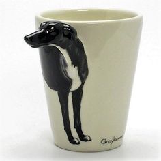 a black and white cup with a dog drawn on it's side, in front of a white background