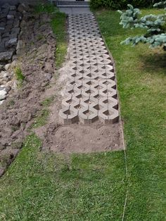 a walkway made out of bricks in the grass