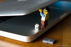 a lego man sitting on top of a laptop computer