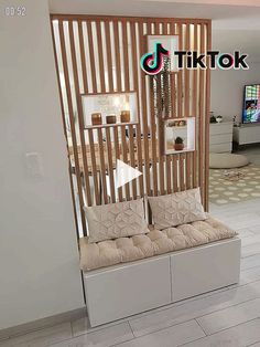 a living room with a couch and wooden slats on the wall, in front of a flat screen tv