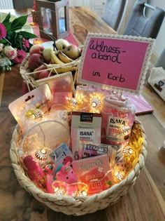 a basket filled with lots of items on top of a wooden table next to a sign