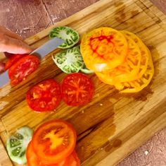 a person slicing tomatoes on a cutting board